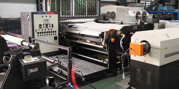 Machine d'enduction par extrusion de bande adhésive thermofusible